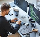Hombre tecleando en un ordenador mientras consulta los servicios de prevención de Cyberzaintza.