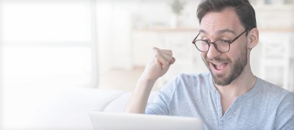 Un hombre haciendo un gesto de felicidad frente a un ordenador, porque ha ganado el Ciber Reto CTF.