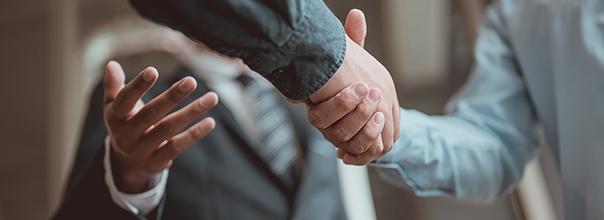 Dos personas dándose la mano en el Consejo Consultivo de Cyberzaintza.